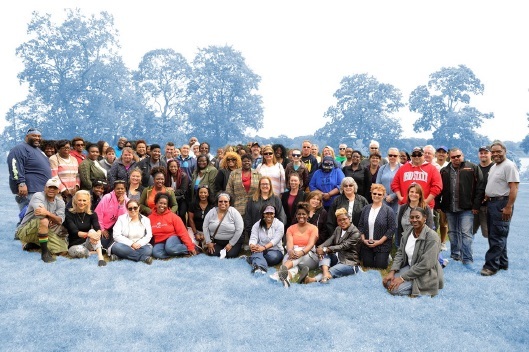 LMHA Staff group photo taken outside some sitting on ground, some standing about 60 people