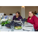 Two women sitting at a table eating a salad