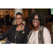 Two women smiling while eating a meal