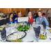 Three women and a man sitting at a table eating a salad