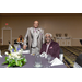 A man standing and another man sitting at a table smile for a picture