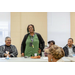 woman in green standing at table speaking