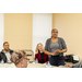 woman in gray standing at table talking